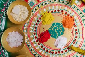 Top view of a traditional festive setup with colorful powders and grains symbolizing a cultural celebration.